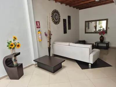 a living room with a white couch and a table at Hotel Brisas MEDELLIN in Medellín
