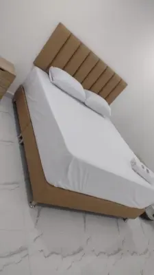 a bed in a room with white sheets and pillows at Hotel Brisas MEDELLIN in Medellín
