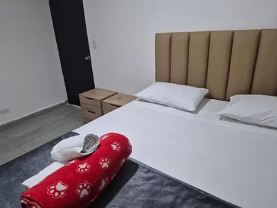 a bedroom with a bed with a red blanket on it at Hotel Brisas MEDELLIN in Medellín