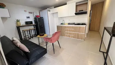a living room with a couch and a kitchen at Aptos y Apartaestudios frente al Malecón y el Embalse, Zona Gastronómica, a 8 minutos de la Piedra del Peñol, TODO CERCA!!! in Guatapé