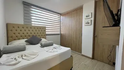 a bedroom with a large bed with a large window at Aptos y Apartaestudios frente al Malecón y el Embalse, Zona Gastronómica, a 8 minutos de la Piedra del Peñol, TODO CERCA!!! in Guatapé