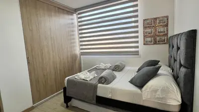 a bedroom with a bed with pillows and a window at Aptos y Apartaestudios frente al Malecón y el Embalse, Zona Gastronómica, a 8 minutos de la Piedra del Peñol, TODO CERCA!!! in Guatapé