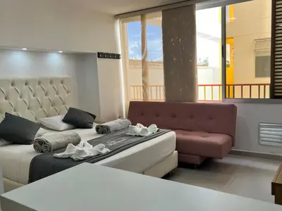 a living room with a bed and a couch at Aptos y Apartaestudios frente al Malecón y el Embalse, Zona Gastronómica, a 8 minutos de la Piedra del Peñol, TODO CERCA!!! in Guatapé