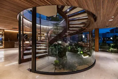 a spiral staircase in a building with plants at Elcielo Hotel Luxury Medellin in Medellín