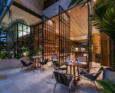 a restaurant with tables and chairs on a patio at Elcielo Hotel Luxury Medellin in Medellín