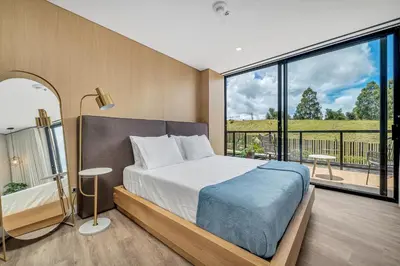 a bedroom with a bed and a large window at Olive Living Suites by HOUSY in Envigado