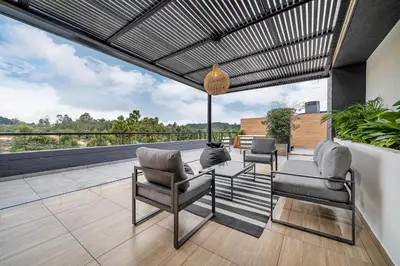 a patio with two chairs and a table on a balcony at Olive Living Suites by HOUSY in Envigado