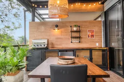an outdoor kitchen with a wooden table and chairs at Olive Living Suites by HOUSY in Envigado