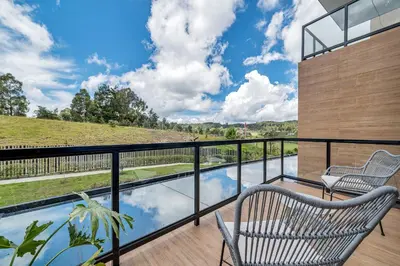 a balcony with two chairs and a swimming pool at Olive Living Suites by HOUSY in Envigado
