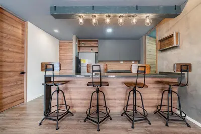 a kitchen with a bar with three stools at Olive Living Suites by HOUSY in Envigado