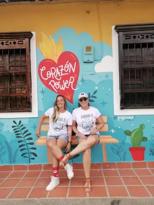 two women sitting on a bench in front of a wall at Casa Amarilla, San Carlos, Antioquia in San Carlos
