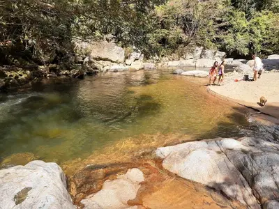 a group of people standing on a beach near a river at Casa Amarilla, San Carlos, Antioquia in San Carlos