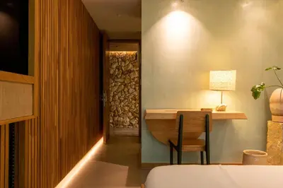 a room with a table with a lamp and a chair at 23 Hotel Medellin in Medellín