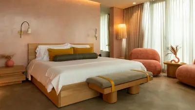 a bedroom with a large bed and a chair at 23 Hotel Medellin in Medellín