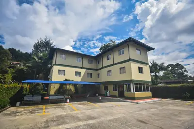 a large yellow building with a blue roof at Finca Hotel Zona Franca in Rionegro