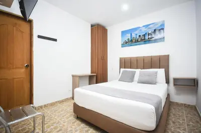 a bedroom with a large white bed and a chair at Finca Hotel Zona Franca in Rionegro