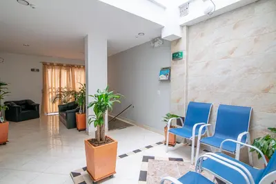 a waiting room with blue chairs and plants at Hotel El Deportista in Medellín