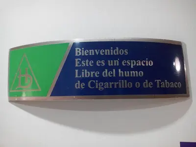 a sign on a wall that reads emergency exit as uraccolele del human at Hotel El Deportista in Medellín