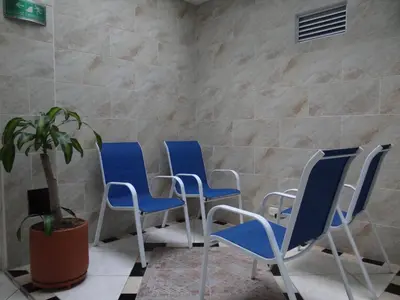 a waiting room with blue chairs and a potted plant at Hotel El Deportista in Medellín