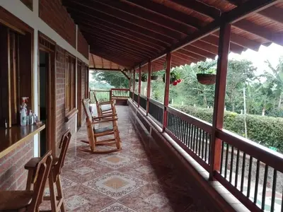 a porch of a house with two chairs on it at Hotel San Felipe Belalcazar in Belcazar Caldas