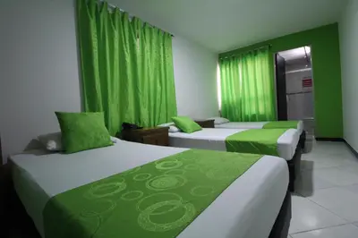 two beds in a room with green curtains at Hotel zandalo medellin in Medellín