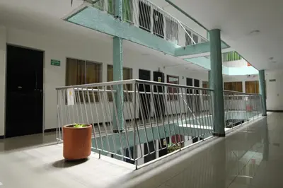 a lobby with a staircase and a pot in a building at Hotel zandalo medellin in Medellín