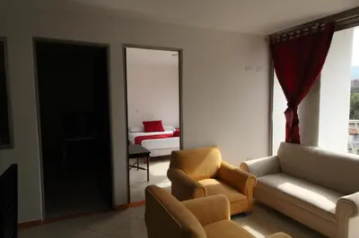 a living room with a couch and a bedroom at Hotel zandalo medellin in Medellín