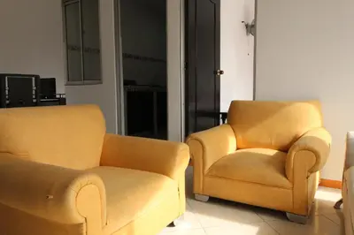 two yellow chairs sitting in a living room at Hotel zandalo medellin in Medellín