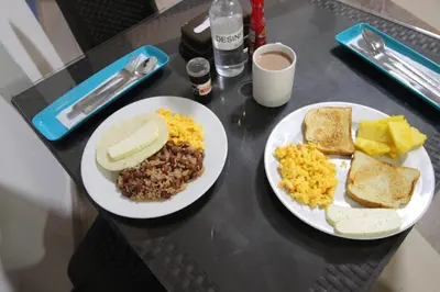 two plates of breakfast food on a table at Hotel zandalo medellin in Medellín