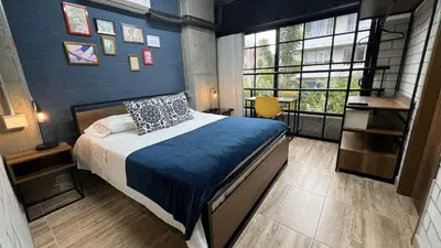a bedroom with a bed with a blue wall at Manila Hotel Boutique in Medellín