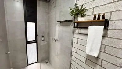 a bathroom with a shower with a white brick wall at Manila Hotel Boutique in Medellín