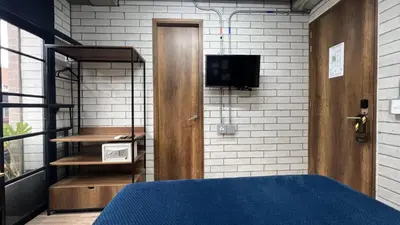 a bedroom with a bed and a tv on a wall at Manila Hotel Boutique in Medellín