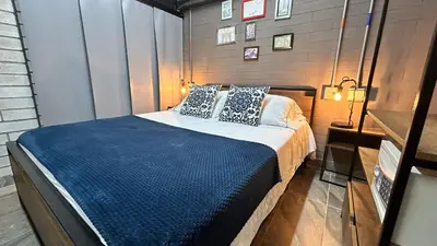 a bedroom with a bed with blue sheets and pillows at Manila Hotel Boutique in Medellín