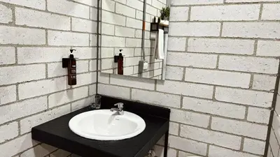 a bathroom with a sink and a brick wall at Manila Hotel Boutique in Medellín