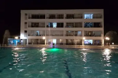 a building with a swimming pool in front of a building at night at Condominio vacacional Paraiso del Sol, San Jeronim in San Jerónimo