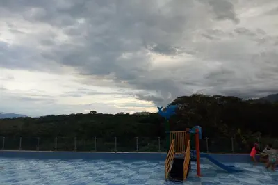 a swimming pool with people playing in the water at Condominio vacacional Paraiso del Sol, San Jeronim in San Jerónimo