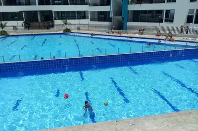 a large swimming pool with a woman playing with a ball at Condominio vacacional Paraiso del Sol, San Jeronim in San Jerónimo