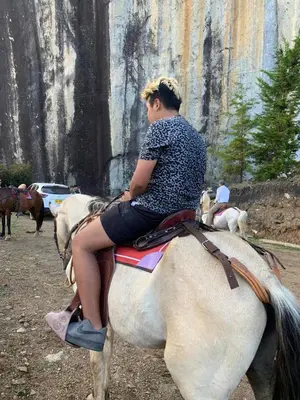 a woman is riding on a white horse at Hotel Bahia Del Faro in Guatapé