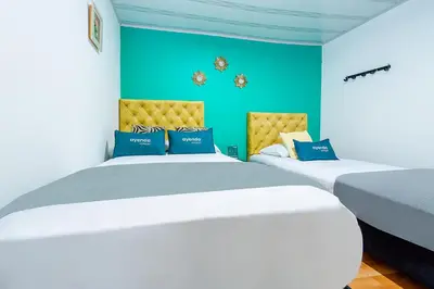 two beds in a room with blue walls at Ayenda Portal del Cable in Manizales