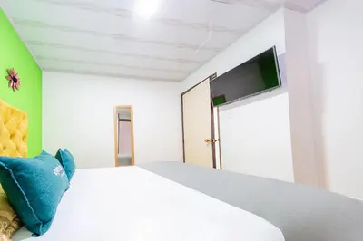 a bedroom with a white bed with blue pillows at Ayenda Portal del Cable in Manizales