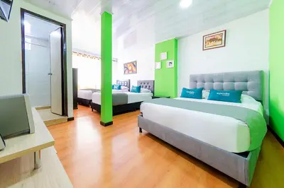 a room with two beds and a television in it at Ayenda Portal del Cable in Manizales