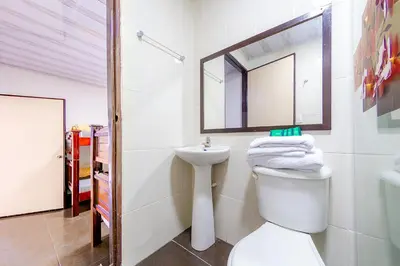 a bathroom with a toilet and a sink and a mirror at Ayenda Portal del Cable in Manizales