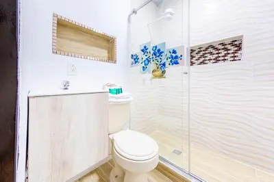 a white bathroom with a toilet and a shower at Ayenda Portal del Cable in Manizales