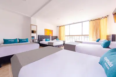 a hotel room with two beds and a large window at Ayenda Portal del Cable in Manizales