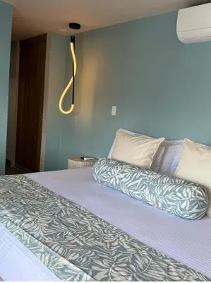 a bedroom with a bed with a blue wall at Kamaleb Farallones Hotel in Quibdó