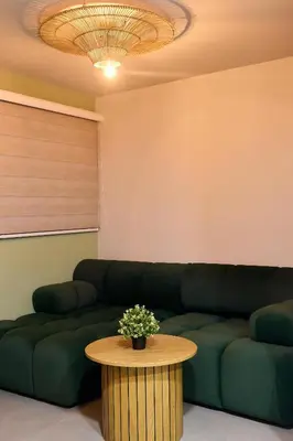 a living room with a green couch and a table at Kamaleb Farallones Hotel in Quibdó