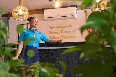 a woman standing in a kitchen with a sign on the wall at Kamaleb Farallones Hotel in Quibdó