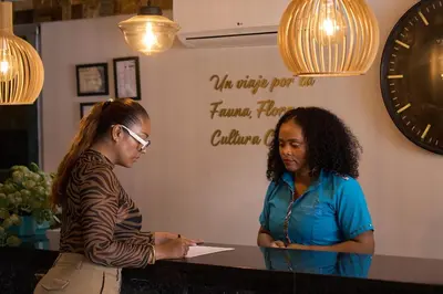 two women standing at a counter in a store at Kamaleb Farallones Hotel in Quibdó