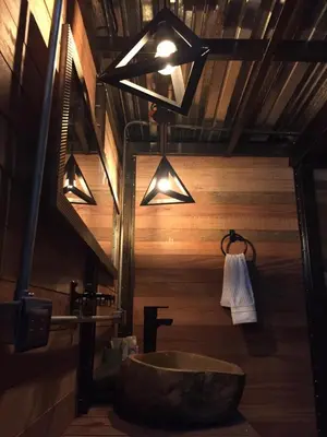 a bathroom with a tub and a sink with lights at Glamping Montecarlo Lodge Cubo de Madera-Guatapé in Guatapé