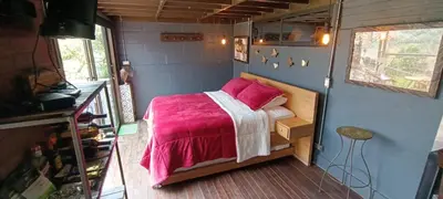 a bedroom with a bed in a tiny house at Glamping Montecarlo Lodge Cubo de Madera-Guatapé in Guatapé